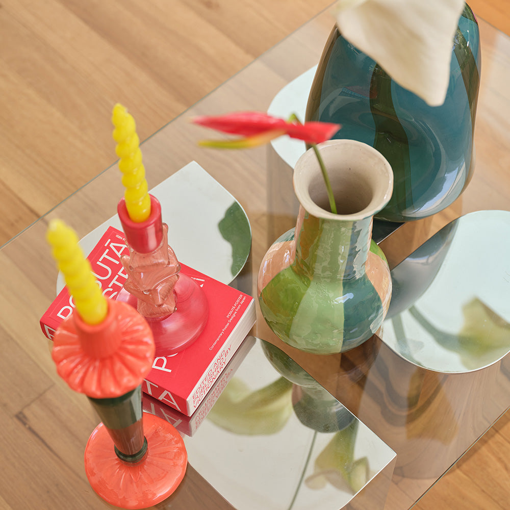 Ceramic Salvador Vase in green, on a living room table, with flared shape and striped pattern.
