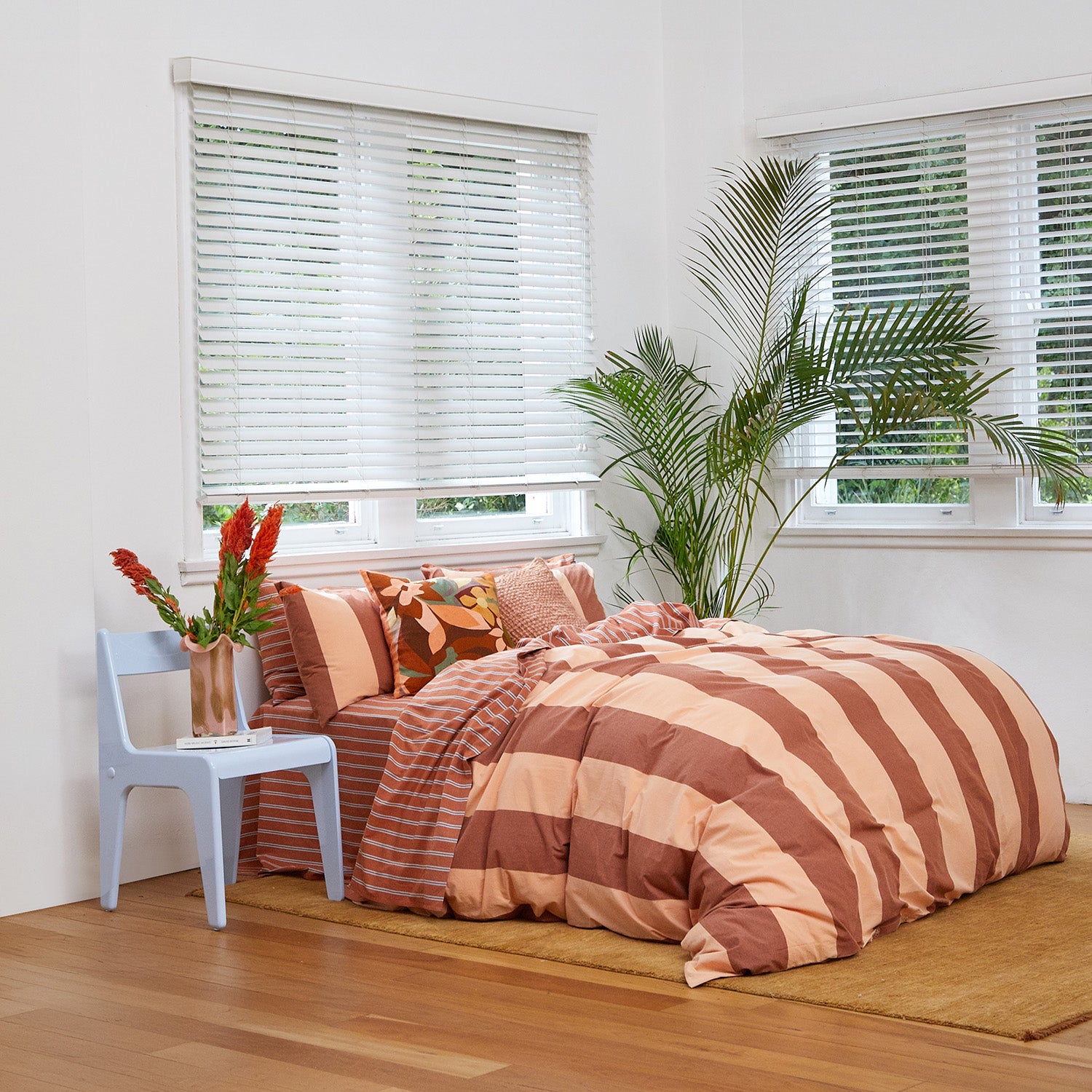 Rust-colored Breeze Quilt Cover Set with bold stripes on a bed