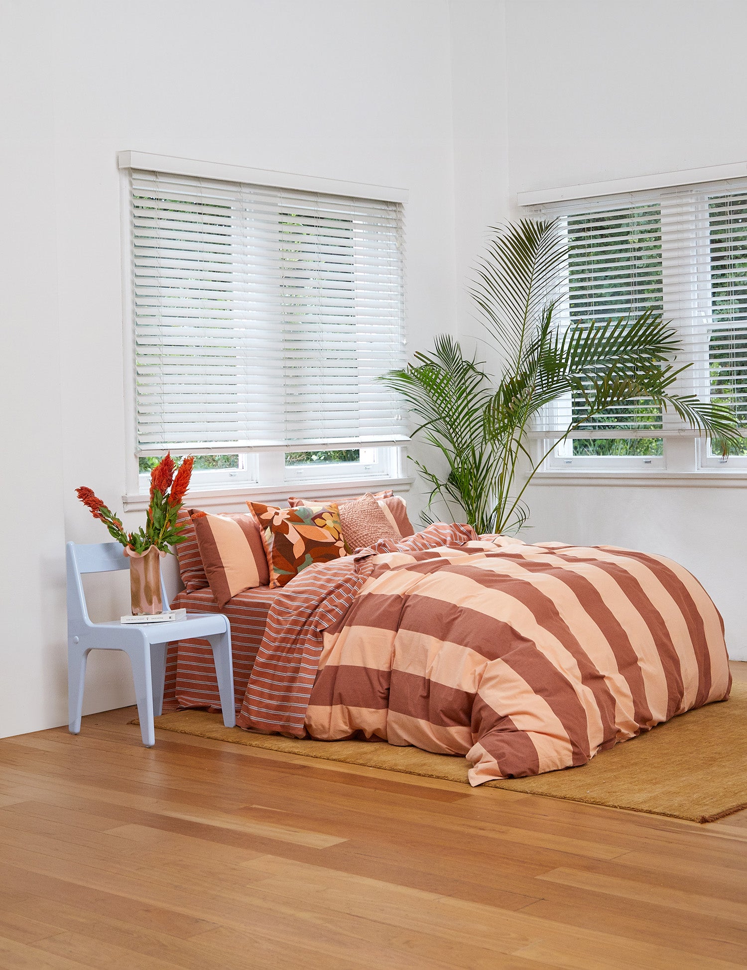 Rust-colored Breeze Quilt Cover Set with bold stripes on a bed