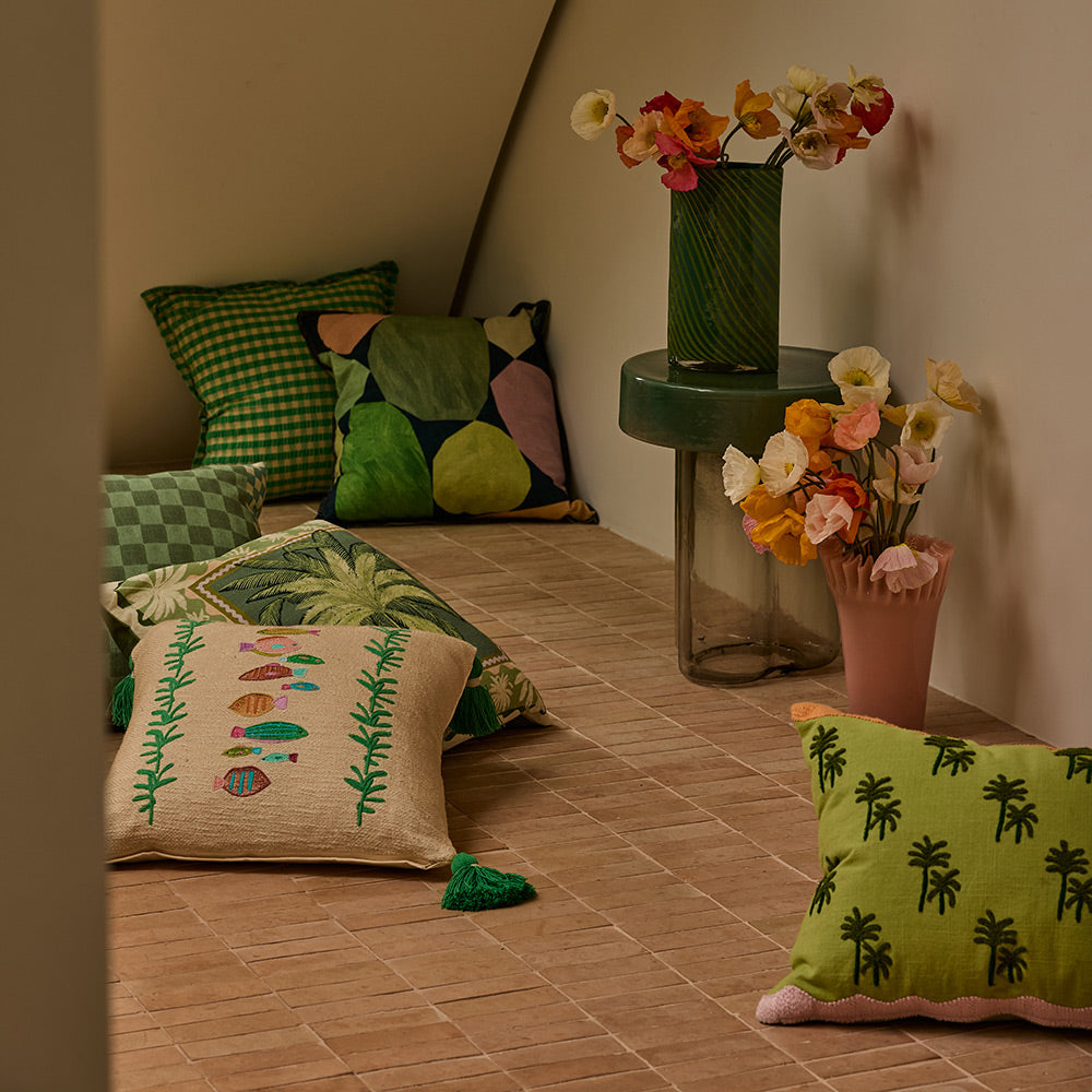 Drake Cushion in lifestyle setting, neutral color, with flat piping detail and velvet reverse.