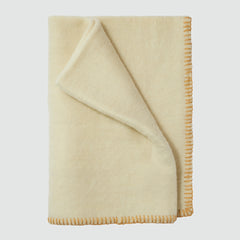 Neutral Livie throw blanket draped over sofa in neutral hue